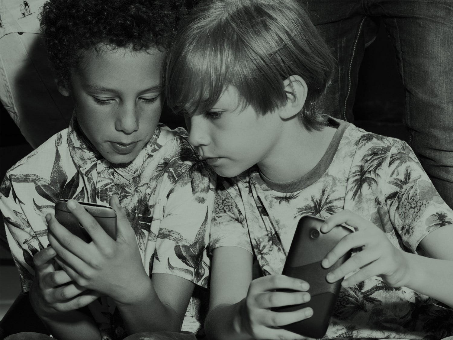 Duas crianças olhando para telefones
