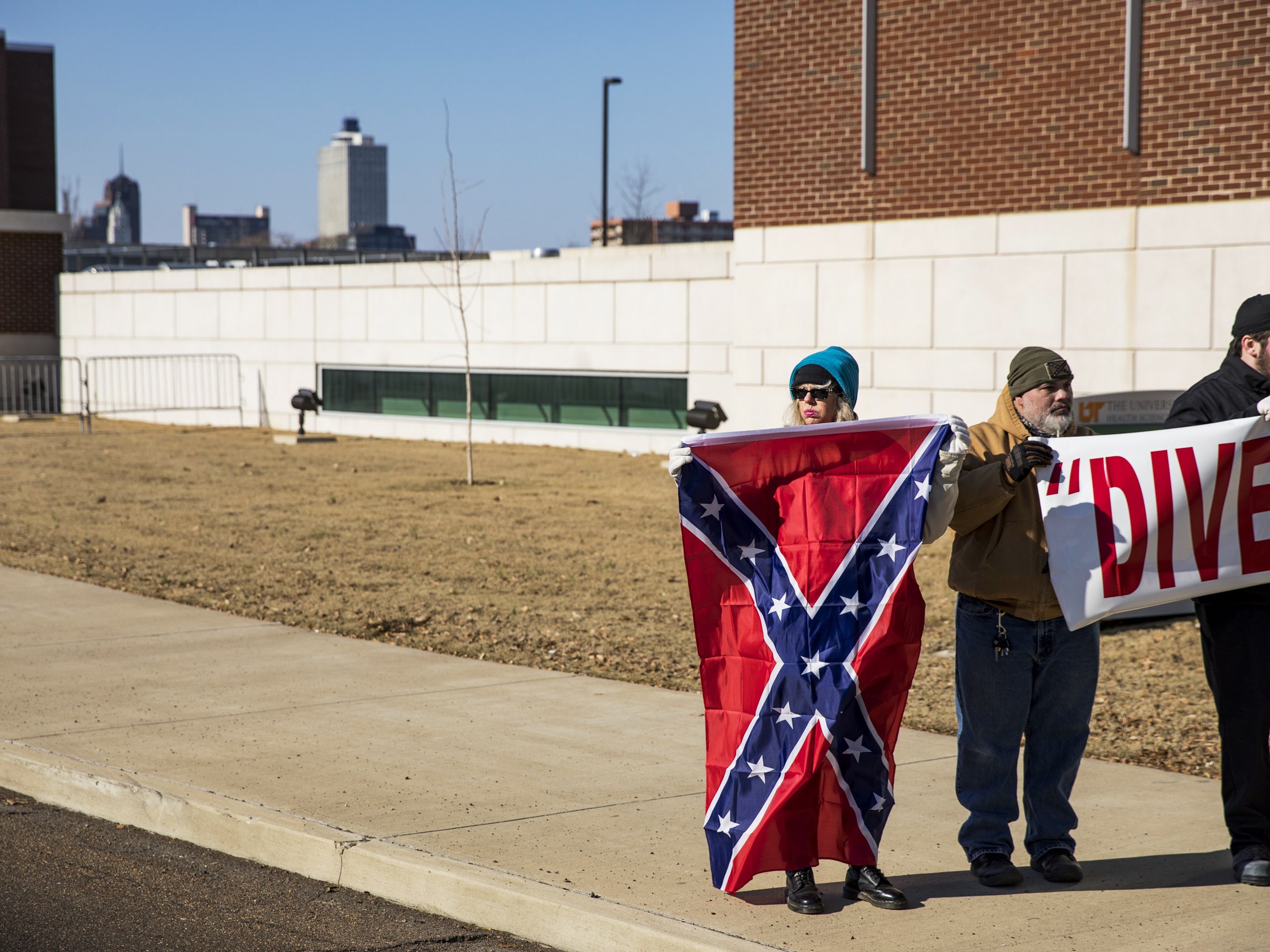 Um grupo de ne o-nazistas possui um pôster e uma bandeira de guerra da Confederação
