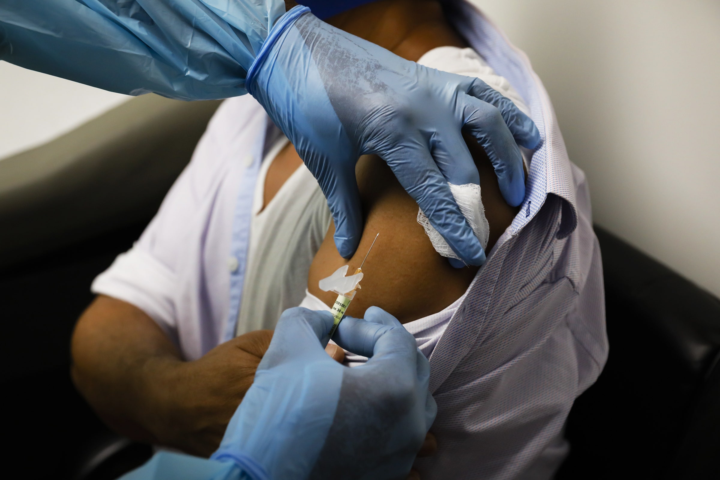 Um trabalhador médico está injetando para uma pessoa durante os testes clínicos da vacina CoVID19