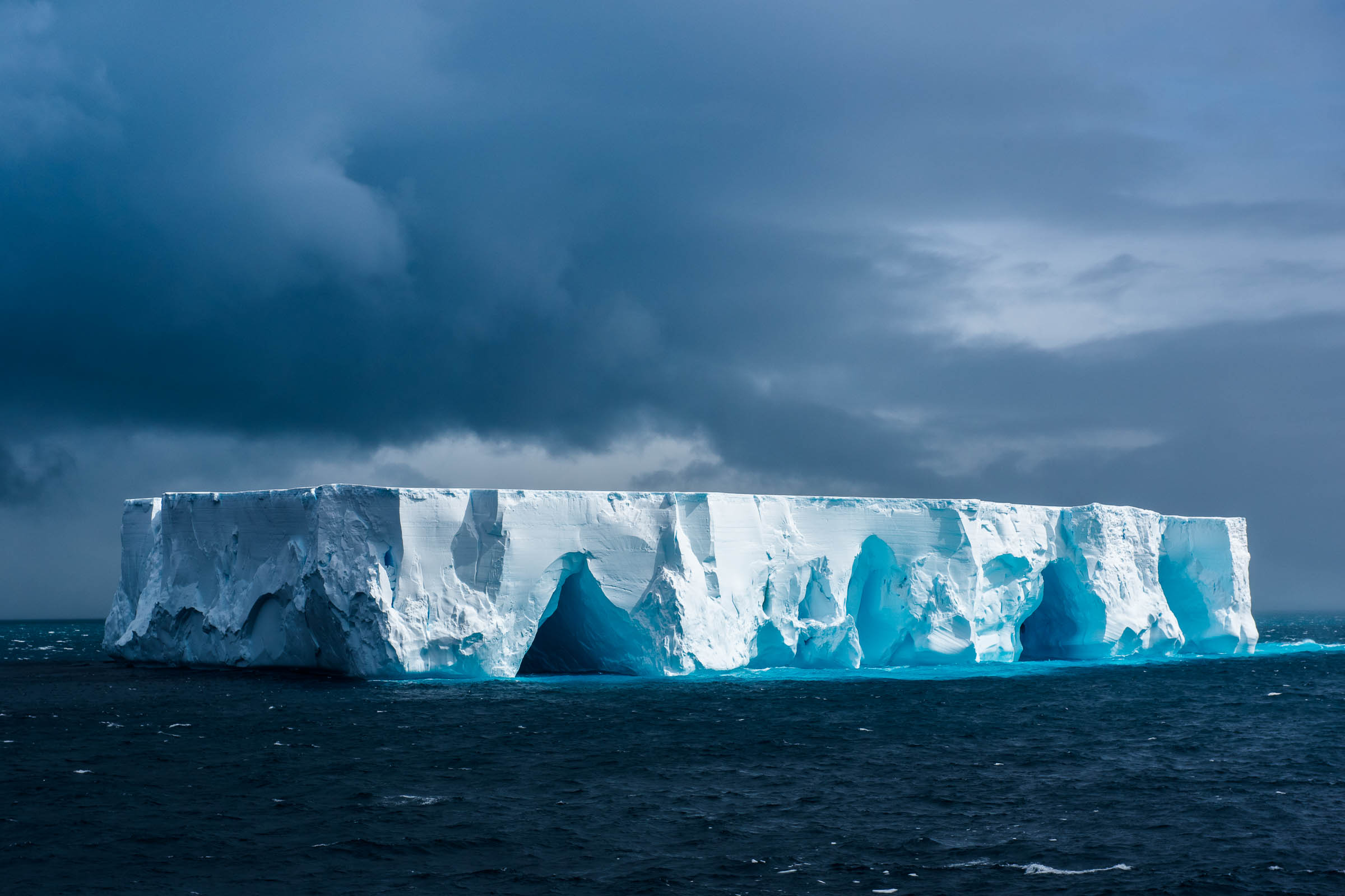 Iceberg maciço flutuando no oceano na Antártica