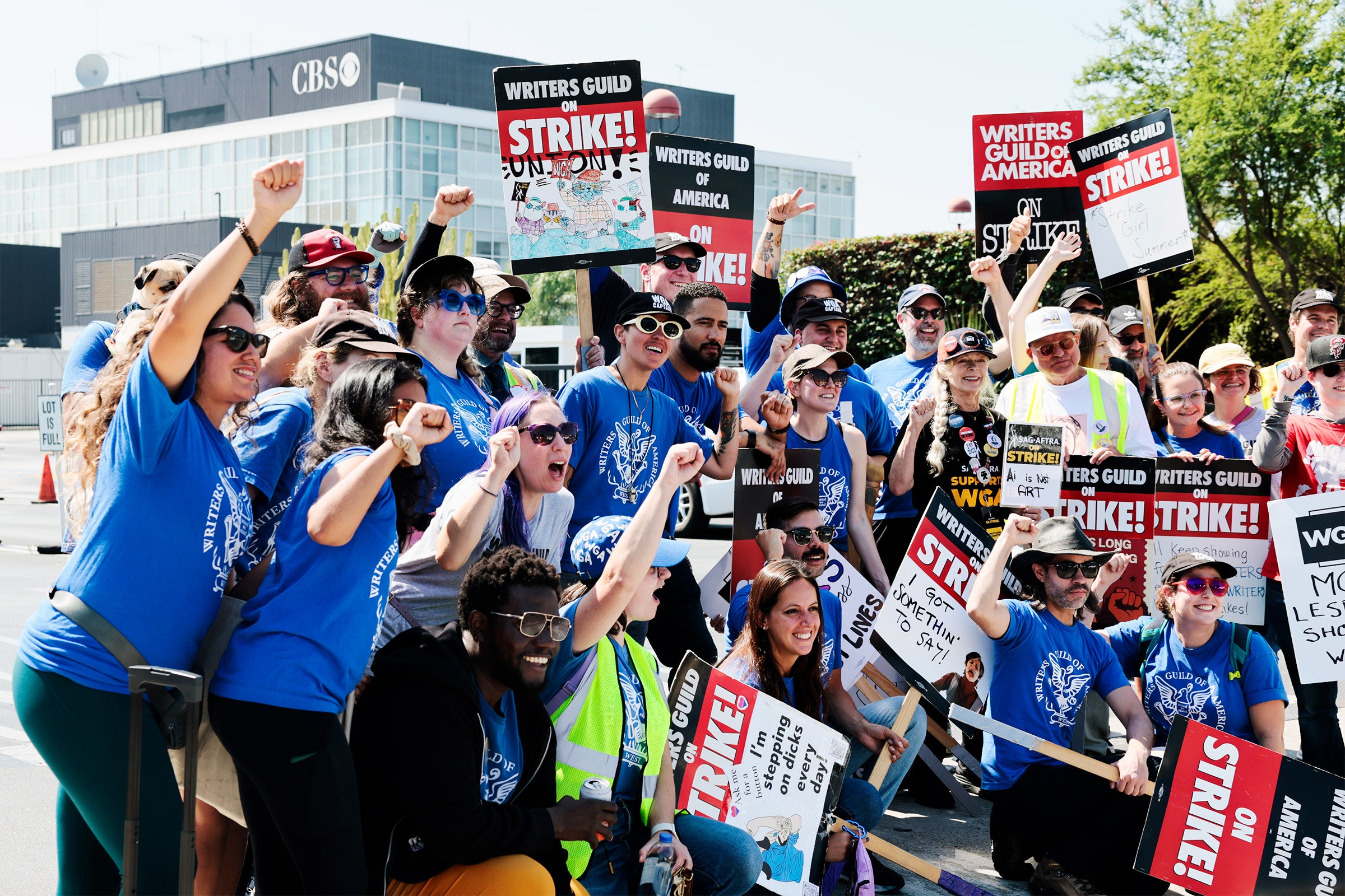 Os membros da WGA se alegram durante uma greve em frente ao estúdio da CBS