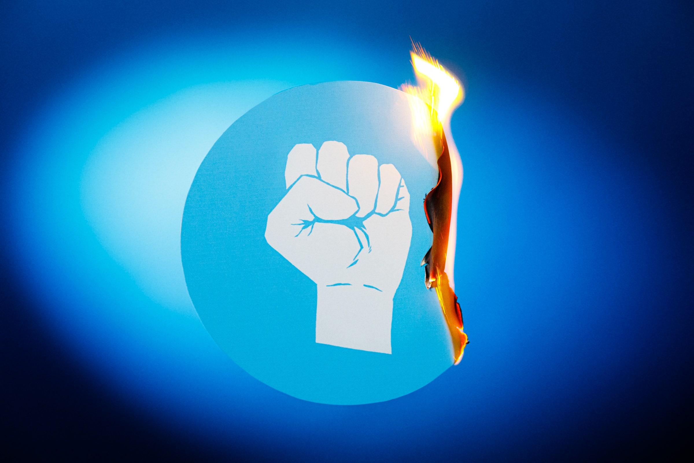 Ilustração de um punho espremido com um objeto em chamas