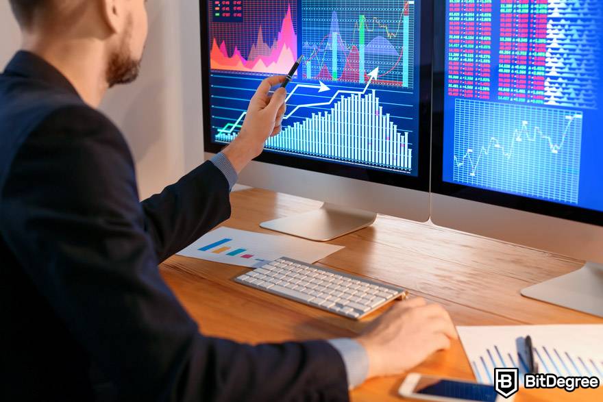 IA de negociação de criptografia: um trader analisa o mercado usando dois monitores.