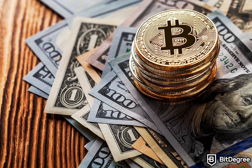 Como negociar criptomoeda: As moedas físicas de Bitcoin são colocadas em cima de notas de dólar.