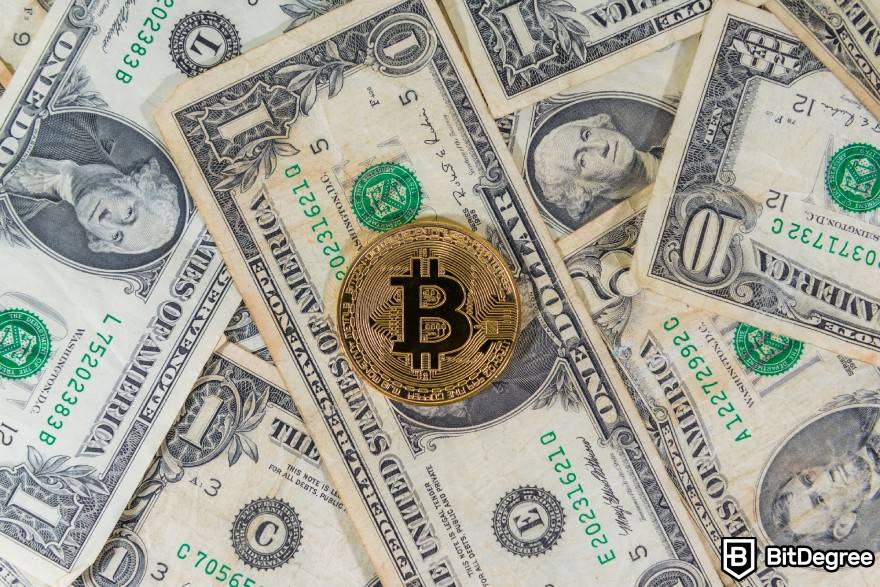 O que é Washing Trading Crypto: Bitcoin físico em um monte de dólares americanos.